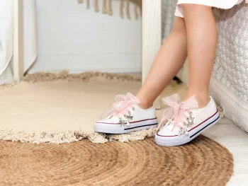 Sneaker de algodón con estampados de encaje en los laterales de color maquillaje suave. Los cordones son en forma de lazada de organza en color natural. Ideales para eventos especiales, bodas y comunión.