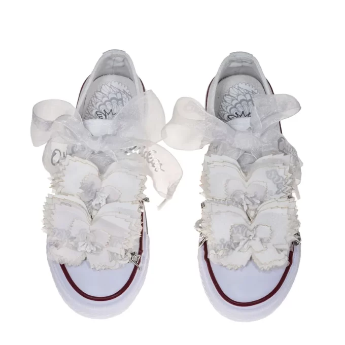 Sneaker de algodón con estampados de mariposas en color gris perla. Están realizadas a mano, lleva mariposas de organza y crepe. Los cordones son en forma de lazada de organza en color blanco con detalle de laminado QUICKAS.
