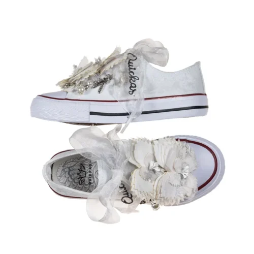 Sneaker de algodón con estampados de mariposas en color gris perla. Están realizadas a mano, lleva mariposas de organza y crepe. Los cordones son en forma de lazada de organza en color blanco con detalle de laminado QUICKAS.