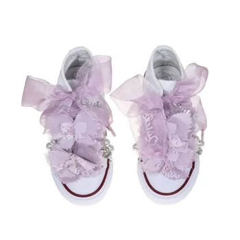 Botas de algodón con puntera con estampados de mariposas en los laterales de color malva. Están realizadas a mano, lleva mariposas de organza y crepe en la parte superior. Los cordones son en forma de lazada de organza en color blanco con detalle de laminado QUICKAS.