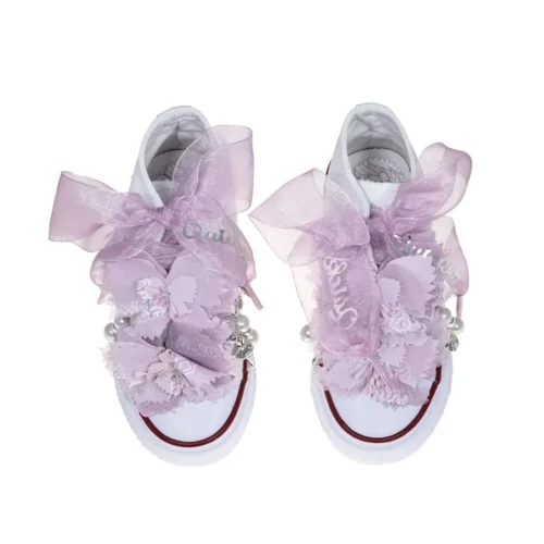 Botas de algodón con puntera con estampados de mariposas en los laterales de color malva. Están realizadas a mano, lleva mariposas de organza y crepe en la parte superior. Los cordones son en forma de lazada de organza en color blanco con detalle de laminado QUICKAS.