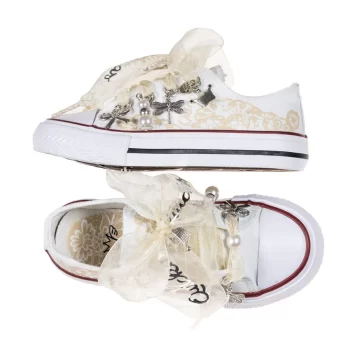 Sneaker de algodón con estampados de encaje en los laterales de color beige suave. Los cordones son en forma de lazada de organza en color natural. Ideales para eventos especiales, bodas y comunión.